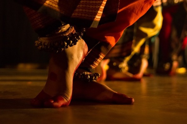 Traditional dancer's feet performing Bharatanatyam wearing dancing anklets on her legs, classical dance South India